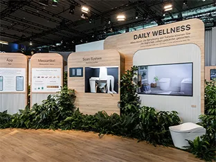 TOTO booth featuring NEOREST smart toilet among wood paneling and foliage at ISH 2025