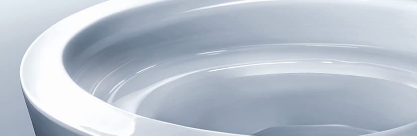 Close up Photo of a toilet bowl with the title of CEFIONTECT over the image. CEFIONTECT is TOTO's special coating on toilets that keeps the toilet cleaner and reduces the amount of harsh chemicals needed to clean the toilet.