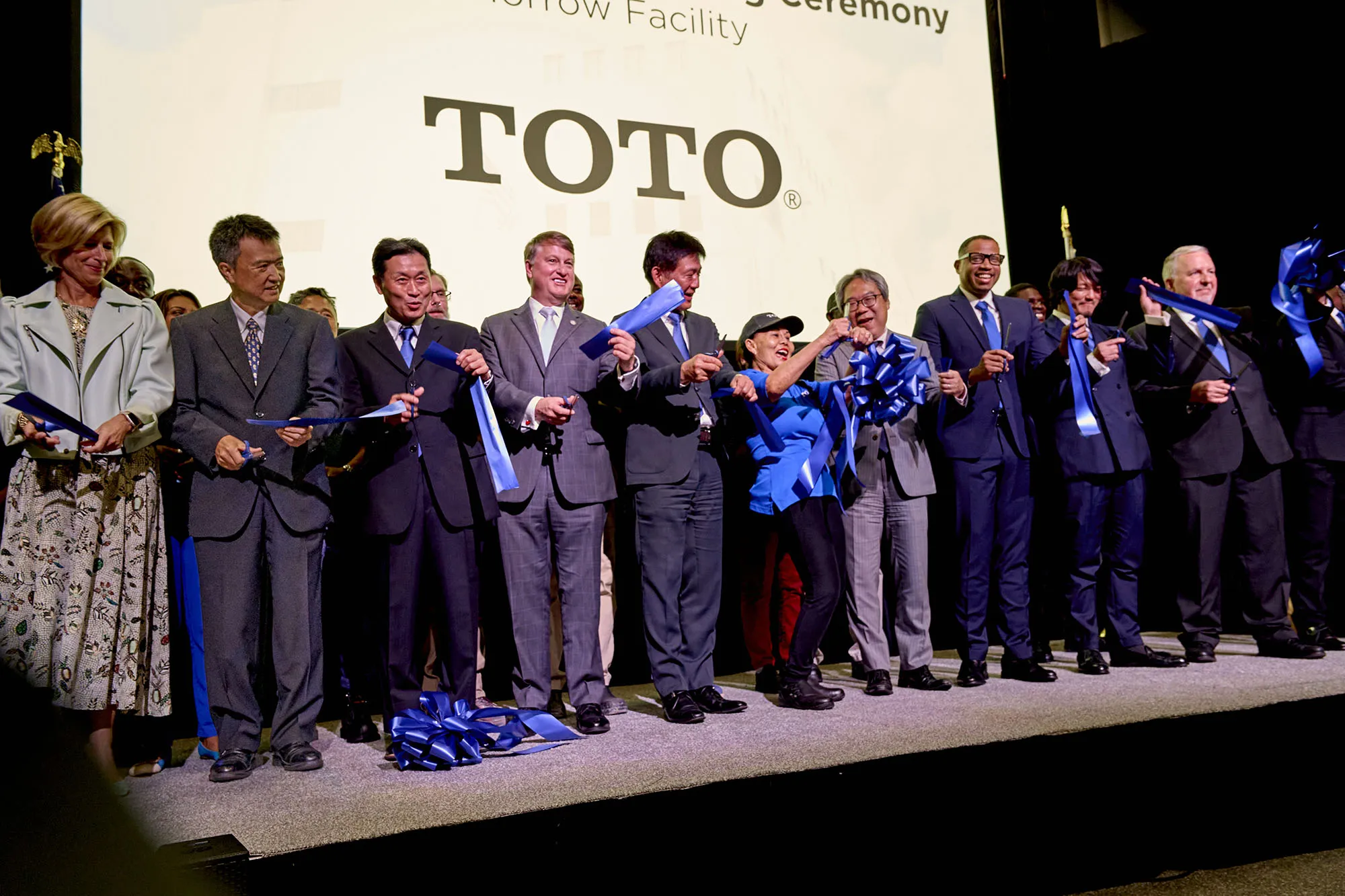 TOTO leaders, employees, state officials, and partners cutting the ceremonial blue ribbon at the 2025 Morrow facility opening.